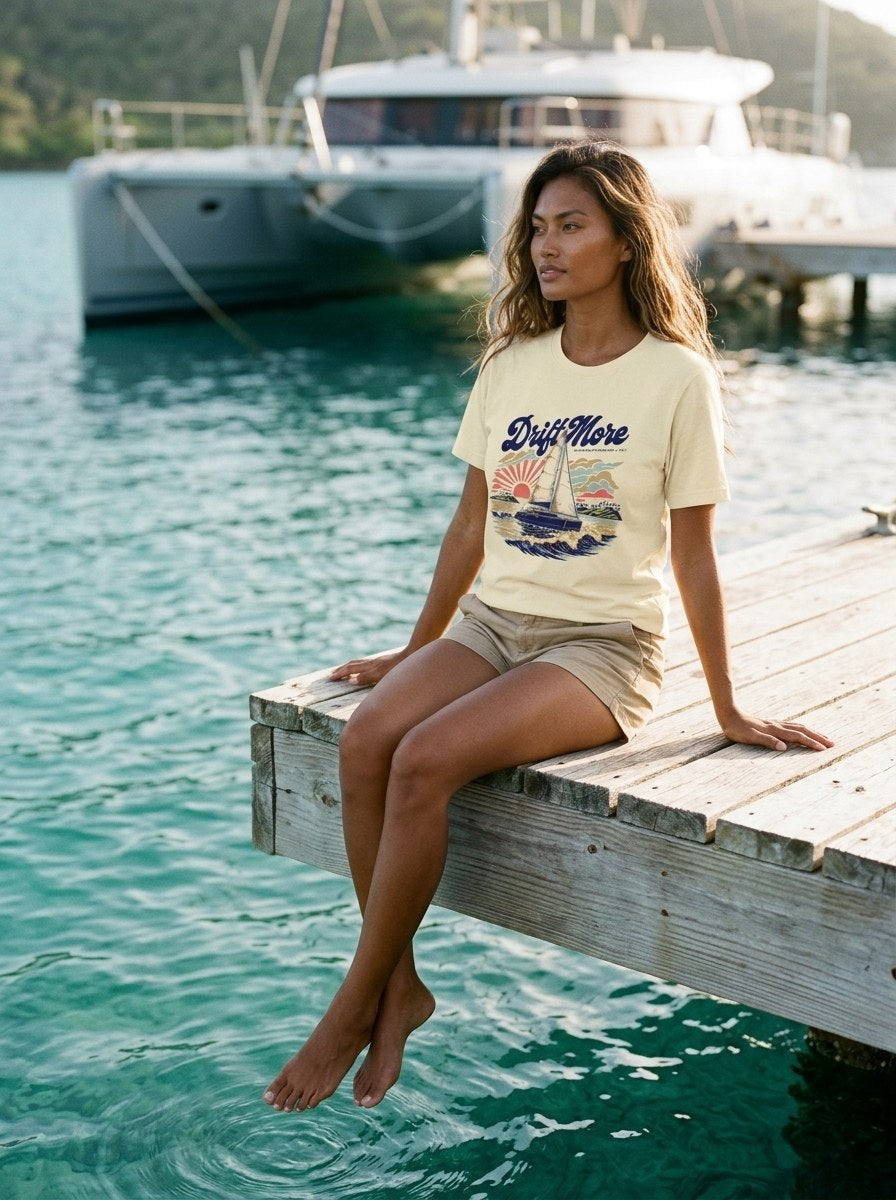 Catamaran BVI Tee in Soft Cream worn on a dock over clear water